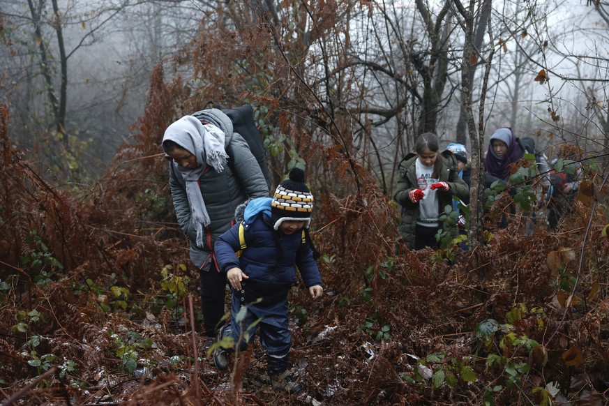 Alia and her 5-year old son walk through a Croatian forest with others after crossing the Bosnia-Croatia border near the Bosnian town of Velika Kladusa, Thursday Dec. 10, 2020. Entire migrant families ...