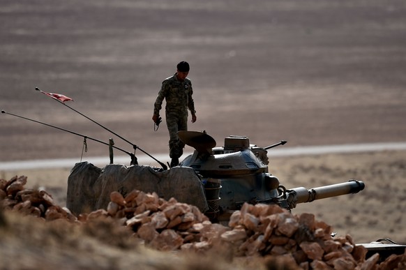 Ein türkischer Soldat auf einem Panzer oberhalb der umkämpften Stadt Kobane – die Türkei zögert noch immer, in Kobane einzugreifen.