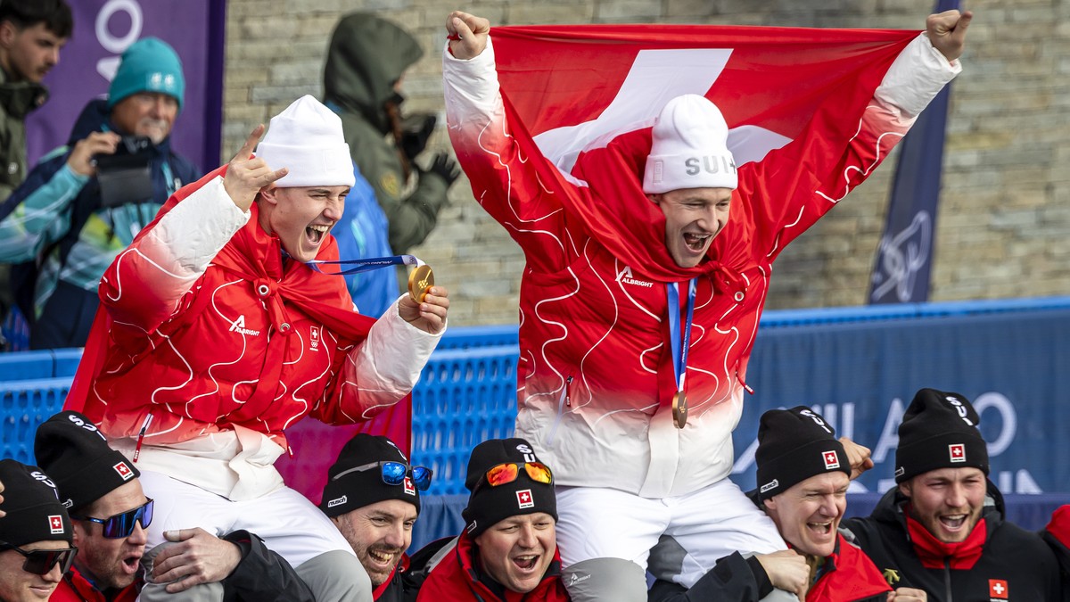 KEYPIX - Gold medalist Franjo von Allmen of Switzerland, left, and bronce medalist Marco Odermatt of Switzerland, pose with team after the men's alpine skiing Super-G race at the 2026 Olympic Win ...