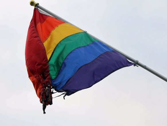A partially burned flag hangs outside the Identity Inc.'s Gay and Lesbian Community Center on Weds., June 24, 2015, in downtown Anchorage, Alaska. Identity Inc. Executive Director Drew Phoenix sa ...