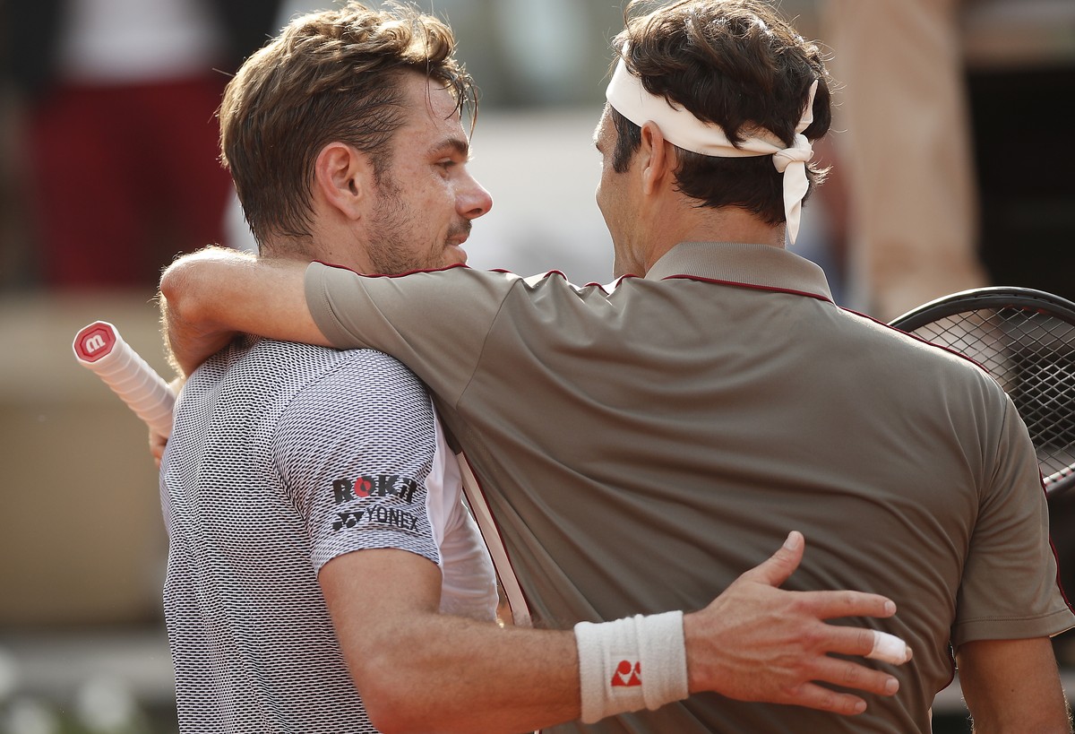 epa07625502 Roger Federer of Switzerland (R) reacts with Stan Wawrinka of Switzerland after winning their men’s quarter final match during the French Open tennis tournament at Roland Garros in Paris, ...