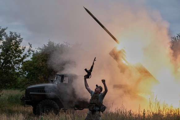 In this photo provided by Ukraine's 93rd Kholodnyi Yar Separate Mechanized Brigade press service, a soldier reacts as an MRLS BM-21 "Grad" fires at the Russian positions near Kostiantyn ...