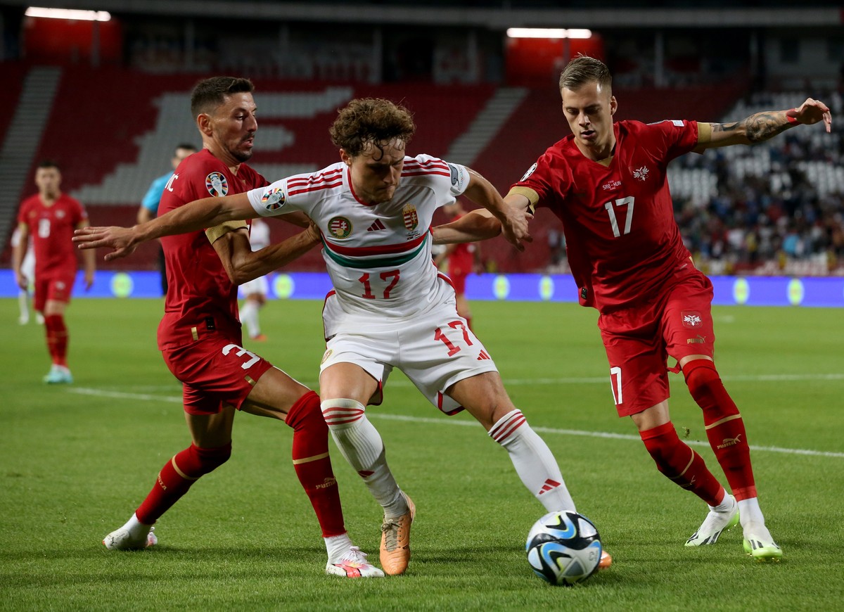 epa10847104 Hungary's Callum Styles (C) in action against Serbia's Filip Mladenovic (L) and Ivan Ilic (R) during the UEFA EURO 2024 qualification match between Serbia and Hungary in Belgrade ...