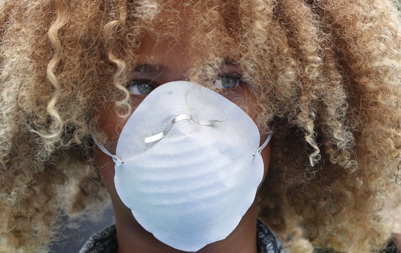 Levi Draheim, 11, wears a dust mask as he participates in a demonstration, Friday, July 12, 2019, in front of the Miami City Hall in Miami. Several youth organizations participated in the demonstratio ...