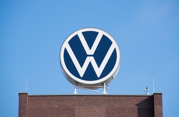 ARCHIV - 11.08.2021, Niedersachsen, Wolfsburg: Das VW-Logo auf fem Markenhochhaus von Volkswagen auf dem Gel