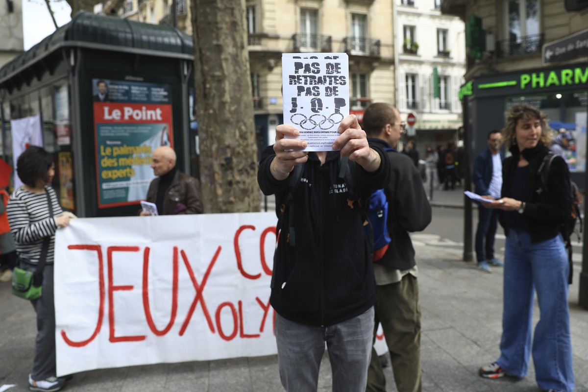 Activists stage a protest against Paris 2024 Olympics, one showing a leaflet reading "No withdrawal of the pension reform, no Olympic Games", in Paris, Monday, May 1, 2023. Olympic contestat ...