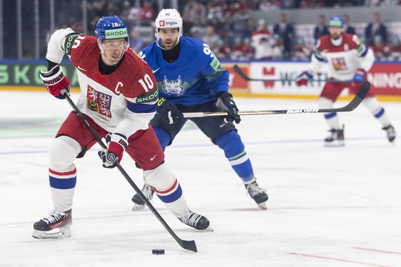 Czechia's Roman Cervenka, left, vies for the puck against Slovenia's Zan Jezovsek, right, during the 2026 IIHF Men's Ice Hockey World Championship preliminary round group B game between ...
