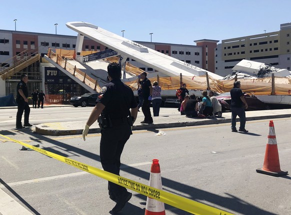 Emergency personnel work at the scene of a collapsed pedestrian bridge at Florida International University on Thursday, March 15, 2018, in the Miami area. The brand-new pedestrian bridge collapsed ont ...