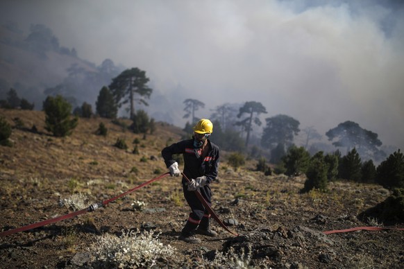 A firefighter adjusts a hosepipe as they extinguish a wildfire in Koycegiz, Mugla, Turkey, Monday, Aug. 9, 2021. Wildfires in Turkey, described as Turkey&#039;s worst in living memory, started on July ...