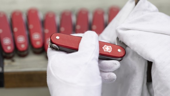 ZUR VICTORINOX STELLEN WIR IHNEN HEUTE FOLGENDES NEUES BILDMATERIAL VON DER PRODUKTION ZUR VERFUEGUNG --- An employee cleans pocket knives and checks their functionality, pictured at the Victorinox fa ...