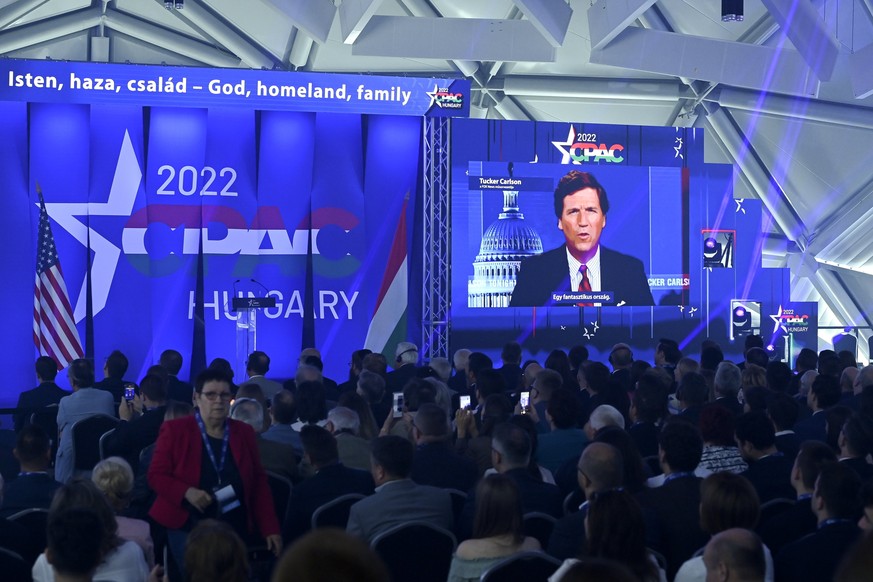 American television host and conservative political commentator Tucker Carlson is seen on screen delivering a speech at the CPAC conference in Budapest, Hungary, Thursday, May 19, 2022. Dozens of prom ...