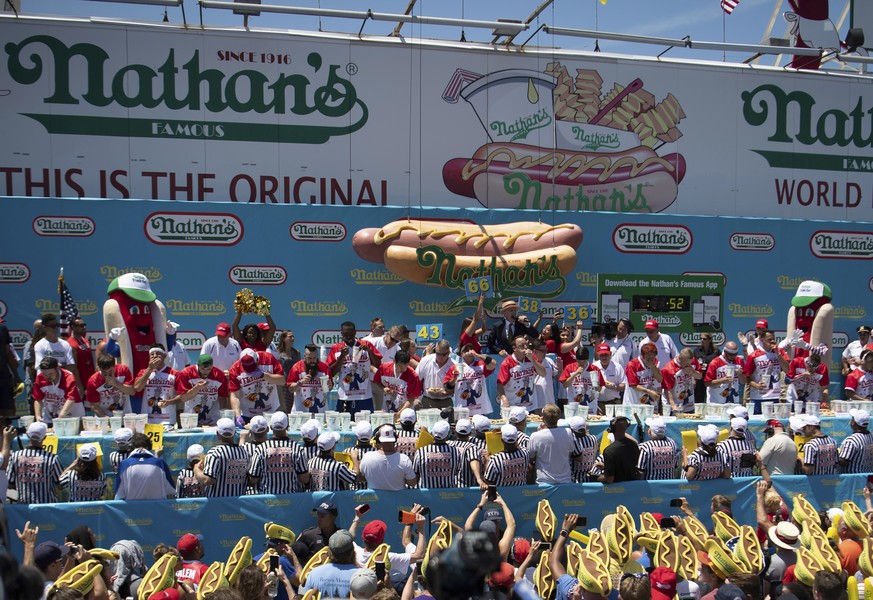 FILE - Competitors consume hot dogs during the men&#039;s competition of Nathan&#039;s Famous July Fourth hot dog eating contest at Coney Island in New York, in this Thursday, July 4, 2019, file photo ...