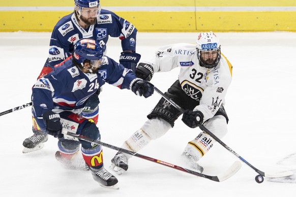 Luganos Sebastien Reuille, rechts, kaempft um den Puck gegen Zuercher Kevin Klein, oben, und Phil Baltisberger, unten, im zweiten Eishockey Playoff-Finalspiel der National League zwischen den ZSC Lion ...