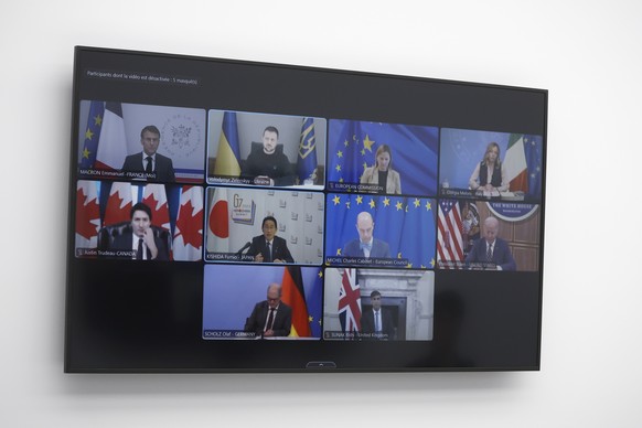 G7 Summit leaders and guests appear on a TV screen at the Elysee Palace in Paris, Thursday, Dec.,6 2023. (Yoan Valat, Pool via AP)
French president Macron takes part in G7 Leaders visioconference
