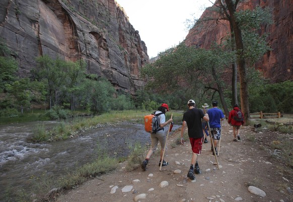 Hikers make their way along the Riverside Walk Trail beside the Virgin River Saturday, Sept., 5, 2009, in Zion National Park, Utah. Both Zion and Bryce were formed millions of years ago when the Earth ...