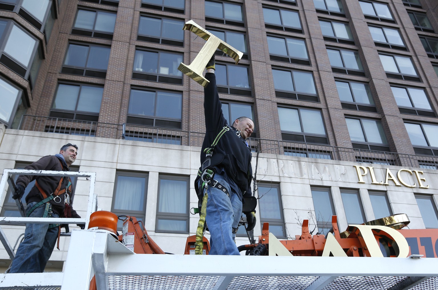 A workman holds up the letter &quot;T&quot; as they remove the letters from a building formerly known as Trump Place in New York, Wednesday, Nov. 16, 2016. Donald Trump&#039;s name is being stripped o ...