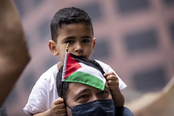 epa09192503 A protester carries his son on his shoulders during a pro-palestinian demonstration in front of the Consulate General of Israel in Los Angeles, California, USA, 11 May 2021. The recent cla ...