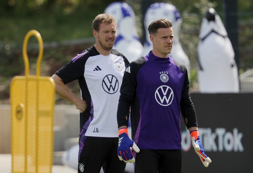 epa11392815 German national soccer team head coach Julian Nagelsmann (L) and goalkeeper Marc-Andre ter Stegen (R) look on during a training session of the team in Herzogenaurach, Germany, 06 June 2024 ...