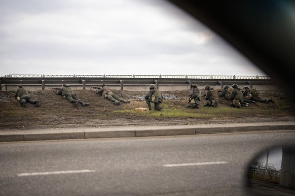 Ukrainische Soldaten gehen unter einer Brücke in Stellung.