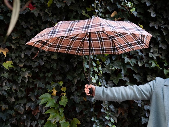Arm der einen Regenschirm hält