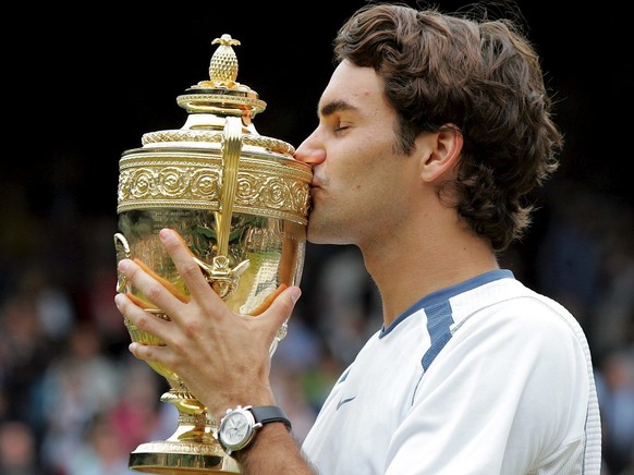 Defending champion Roger Federer of Switzerland kisses the championship trophy following his victory over Andy Roddick of the US in their men&#039;s singles final on Centre Court for the Wimbledon Cha ...