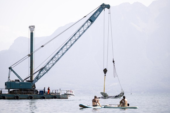 Un avion ICP Savannah S, immatricule F-JLHM, est remorque en dehors du Lac Leman sur une barge de l&#039;entreprise Orlatti lors d&#039;une operation de recuperation par la brigade du lac de la police ...