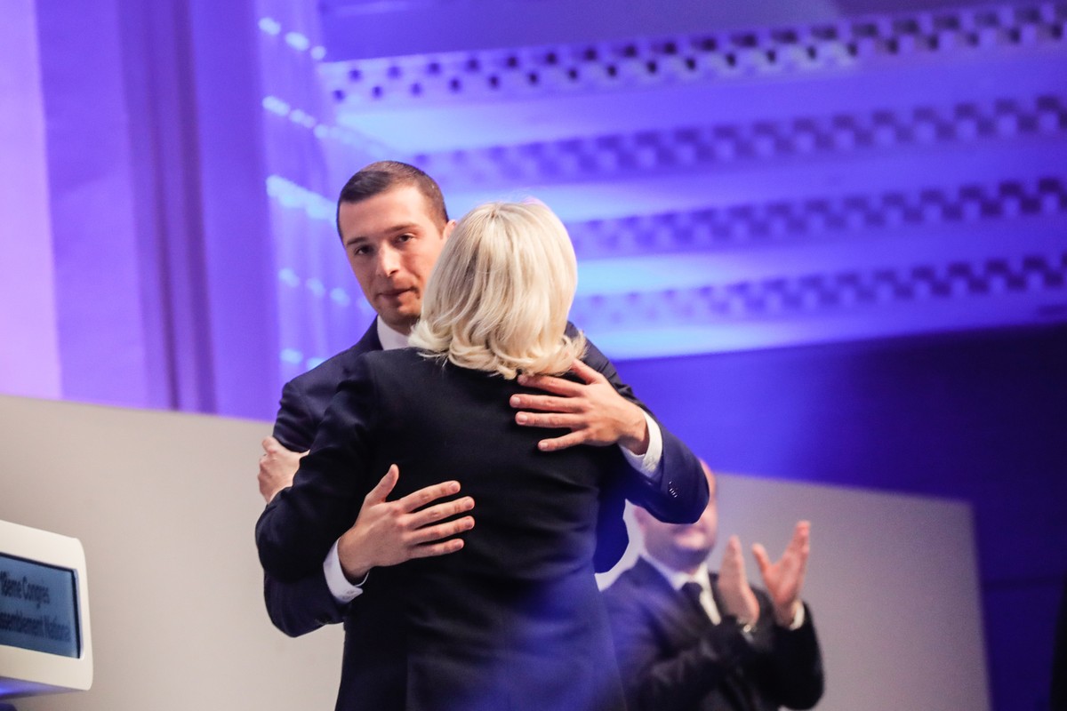 epa10287630 Jordan Bardella (L), newly elected president of France's far right Rassemblement National (RN) party, hugs Marine Le Pen, the party's former president, during the 18th RN party C ...