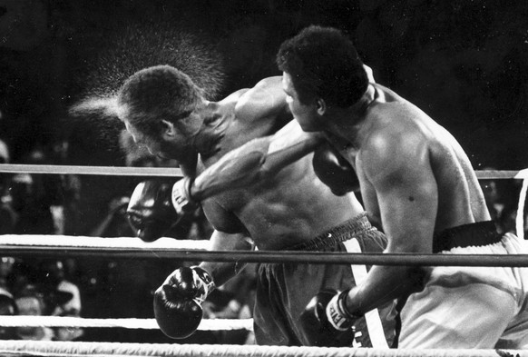 FILE - This is a Oct. 30, 1974  file photo perspiration flies from the head of George Foreman as he takes a right from challenger Muhammad Ali in the seventh round in the match dubbed Rumble in the Jungle in Kinshasa, Zaire.  Foreman was knocked out in the eighth round. It was 40 years ago that two men met just before dawn on Oct. 30, 1974, to earn $5 million in the Rumble in the Jungle. In one of boxing's most memorable moments, Muhammad Ali stopped the fearsome George Foreman to recapture the heavyweight title in the impoverished African nation of Zaire.  (AP Photo/Ed Kolenovsky, File)