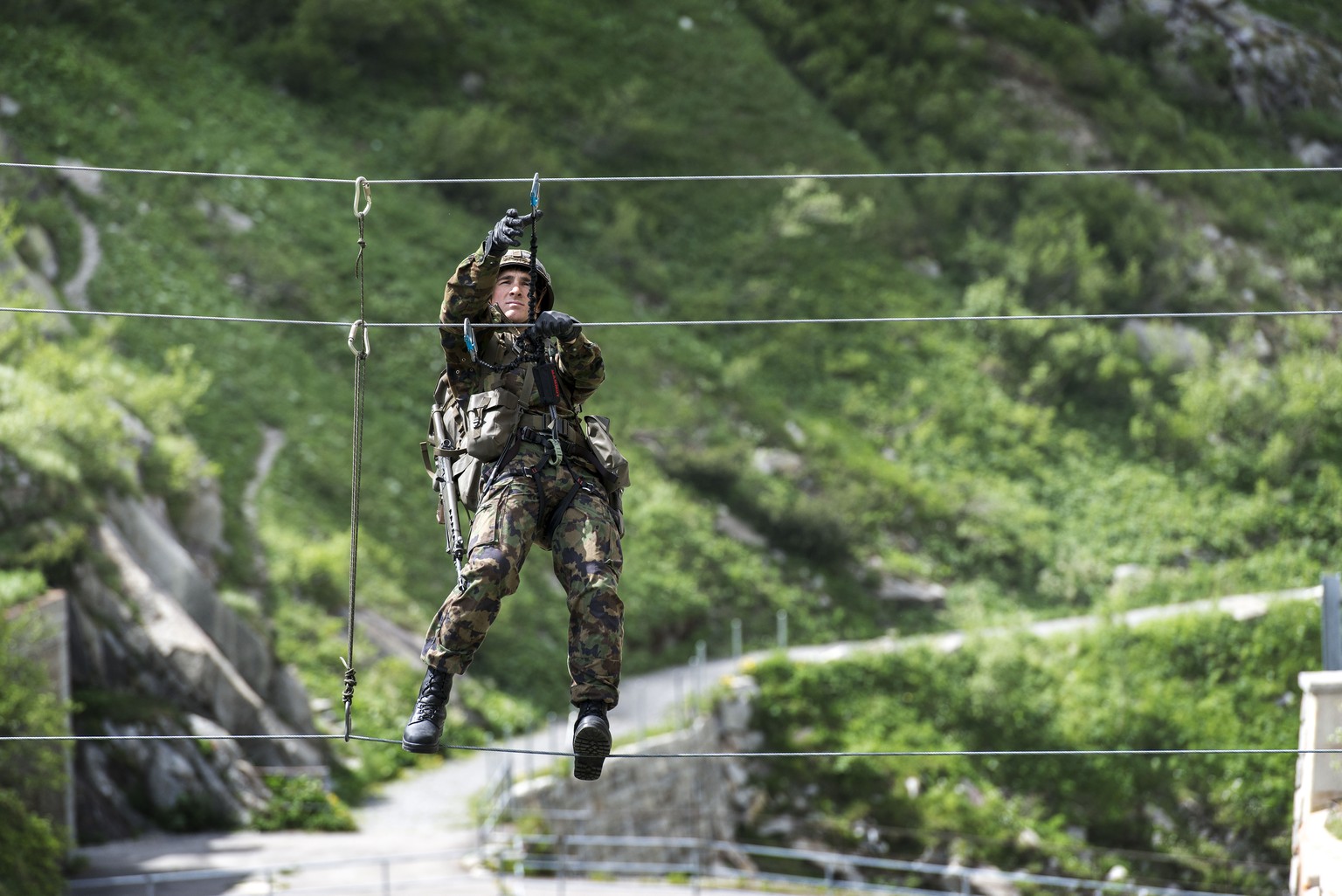 Ein Gebiergsspezialist der Schweizer Armee überquert eine Schlucht bei Andermatt.