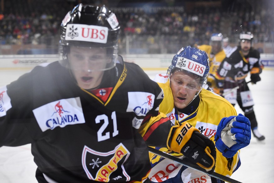 epa07254473 Kalpa&#039;s Eetu Luostarinen, left, and Davos&#039; Chris Egli fight for the puck during the game between HC Davos and KalPa Kuopio Hockey Oy at the 92th Spengler Cup ice hockey tournamen ...