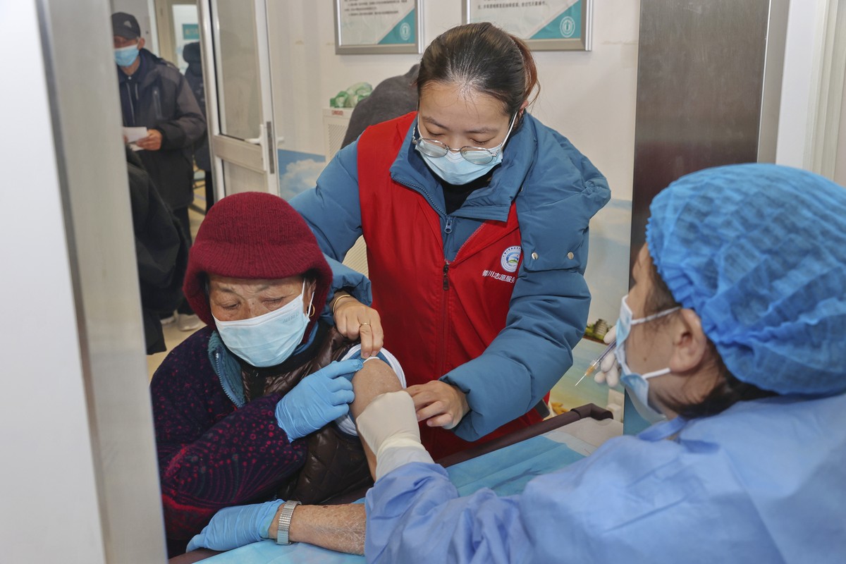 An elderly woman gets vaccinated against COVID-19 at a community health center in Nantong in eastern China's Jiangsu province on Dec. 9, 2022. The National Health Commission announced a campaign  ...