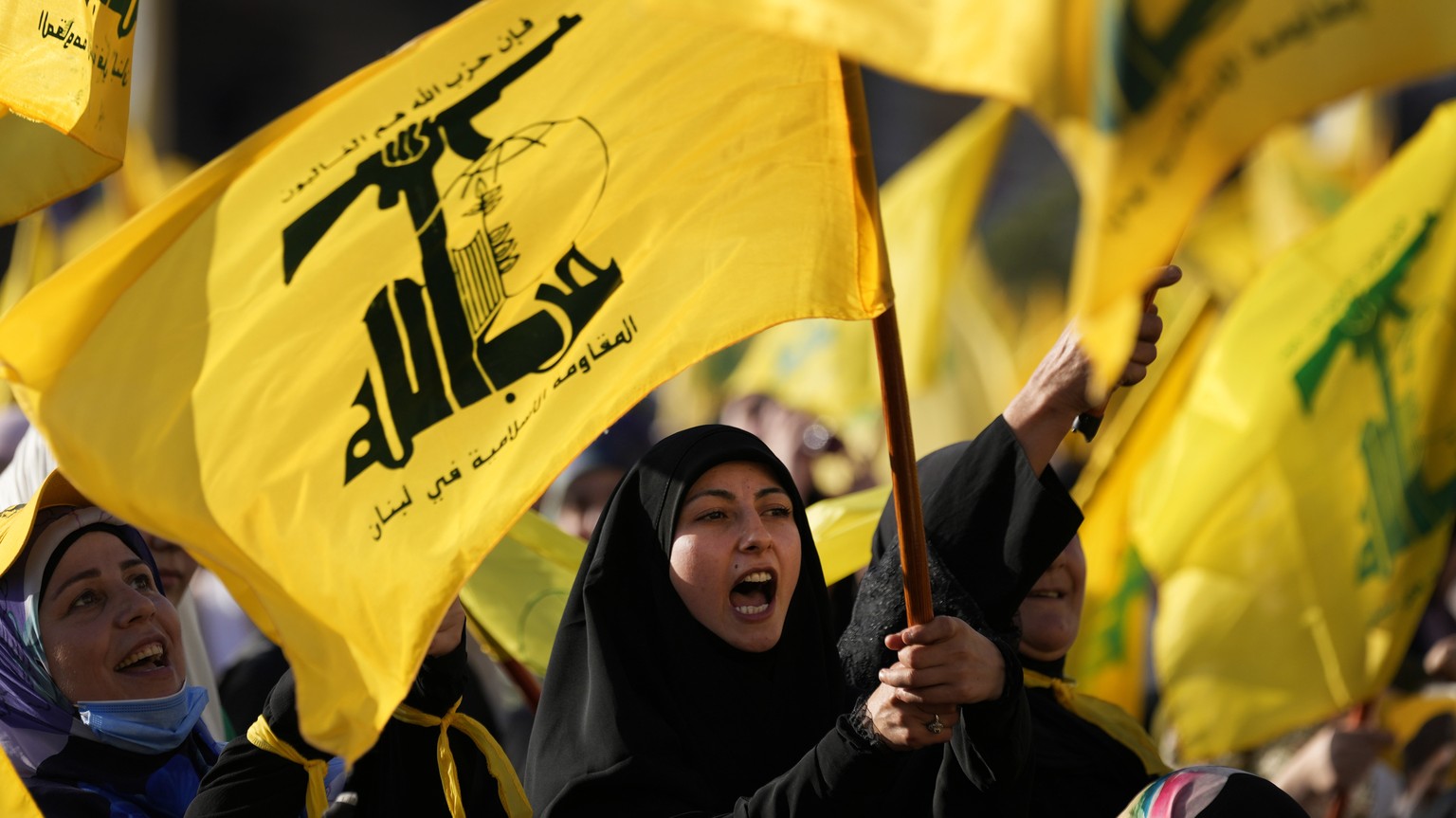 A Hezbollah supporter shouts slogans and waves her group flag, during an election campaign, in the southern suburb of Beirut, Lebanon, Tuesday, May 10, 2022. The parliamentary elections will take plac ...