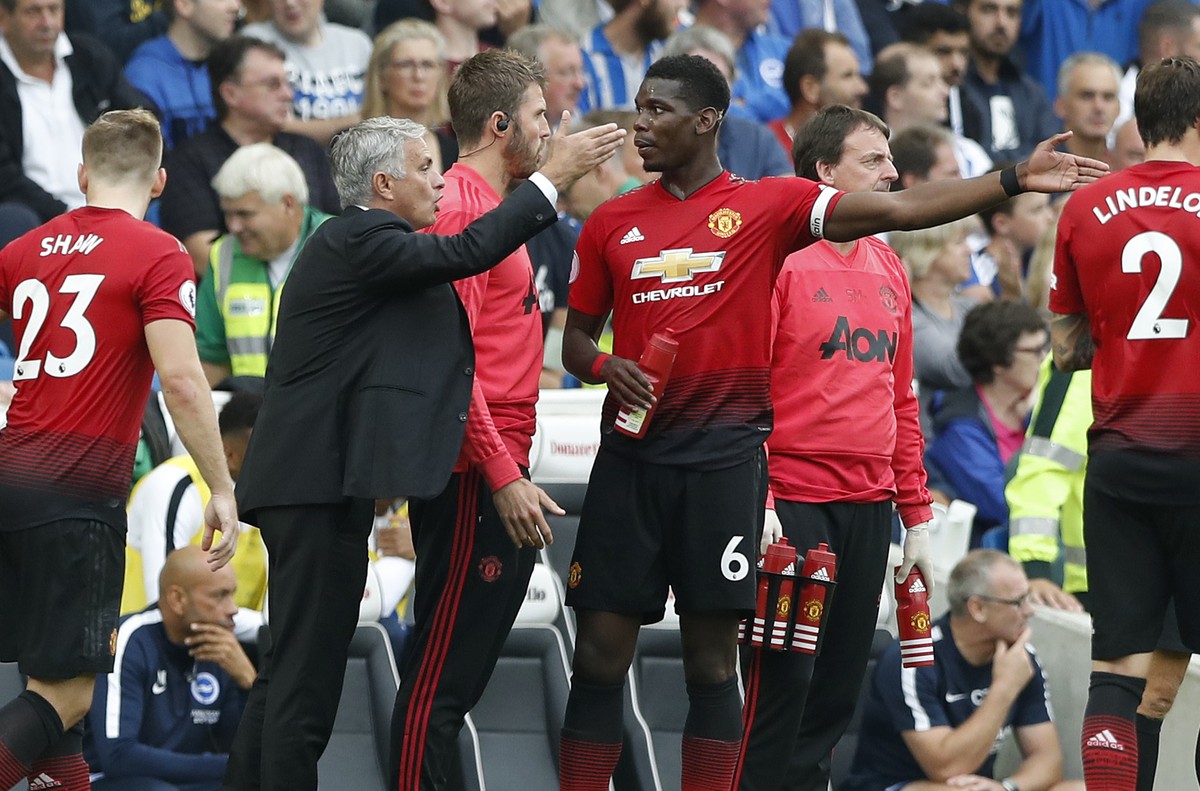 Manchester United's manager Jose Mourinho, center, gestures as he speaks to Paul Pogba during the English Premier League soccer match between Brighton and Hove Albion and Manchester United at the ...