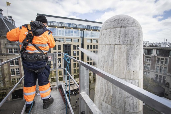epa10604159 An employee of the city cleaning service sprays the National Monument on Dam Square in the run-up to Remembrance Day, in Amsterdam, the Netherlands, May 02, 2023. True to tradition, the n ...