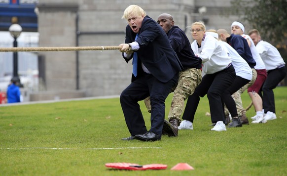 FILE - In this Oct. 27, 2015 file photo Boris Johnson takes part in a tug of war with Armed Forces personnel at the launch of London Poppy Day during his tenure as Mayor of London. (Jonathan Brady/PA  ...