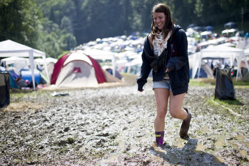 Eine Frau laeuft durch den Schlamm, am Openair St. Gallen am Freitag, 1. Juli 2011 im Sittertobel St. Gallen. (KEYSTONE/Ennio Leanza)....A Festival-goer walks through mud at the Openair St. Gallen Fes ...