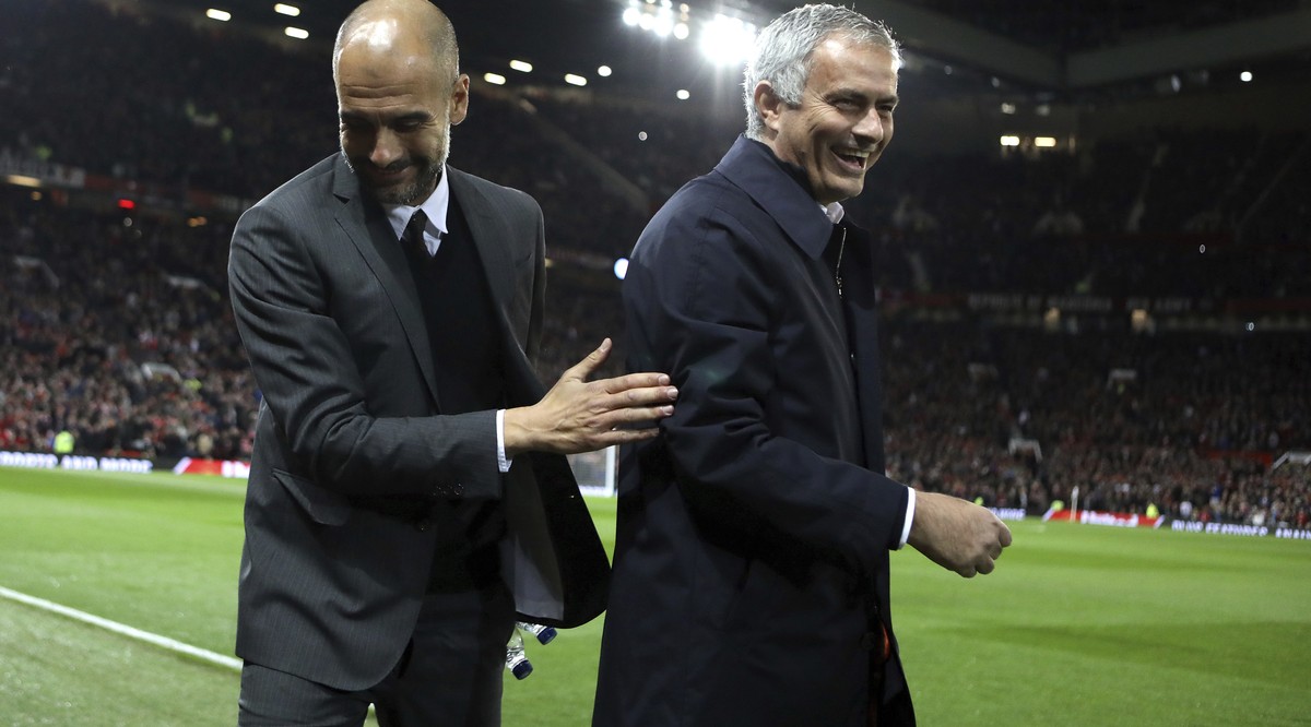 Manchester City's manager Pep Guardiola, left, and Manchester United's manager Jose Mourinho smile ahead of the English League Cup soccer match between Manchester United and Manchester City  ...