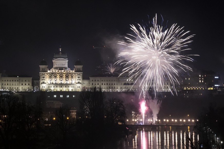 Fireworks pictured next to the Federal Palace, Switzerland's parliament building, during New Year's celebrations in Bern, Switzerland, Monday, January 1, 2024. (KEYSTONE/Anthony Anex)