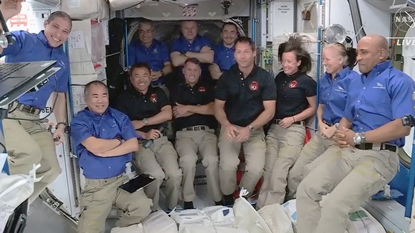 epa09157030 A handout photo made available by the NASA shows a NASA TV grab with the Space-X Crew-2 members (center L-R) JAXA (Japan Aerospace Exploration Agency) astronaut Akihiko Hoshide, NASA astro ...