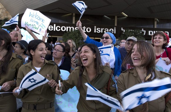 epa04350032 Israeli soldiers among people cheering a group of 338 Americans and Canadians arriving at Ben Gurion Airport, in Lod, outside Tel Aviv, Israel, 12 August 2014. According to media reports,  ...