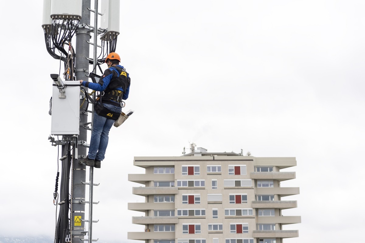 Un employe de l'entreprise Axians installe une antenne 5G de communication pour les mobiles sur un mat situe sur le toit d'un immeuble du quartier de la Gradelle a Chene-Bougeries ce vendred ...