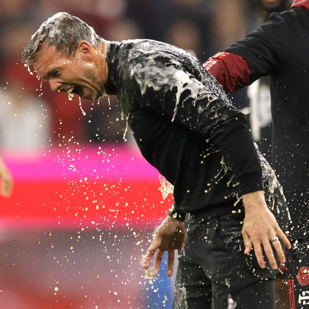epa09904949 Bayern's head coach Julian Nagelsmann (L) receives a beer shower from Bayern Munich's assistant coach Holger Broich (R) celebrating the tenth consecutive Bundesliga title, after  ...