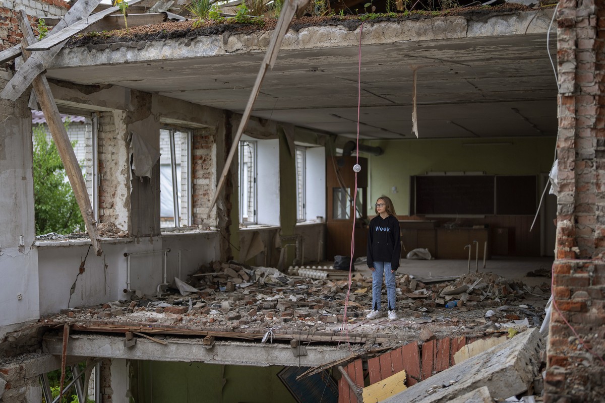 Anna Skiban, 12, stands in the rubble of her former classroom, in the same position where her desk sat before the Mykhailo-Kotsyubynske's lyceum was bombed by Russian forces on March 4, in Cherni ...
