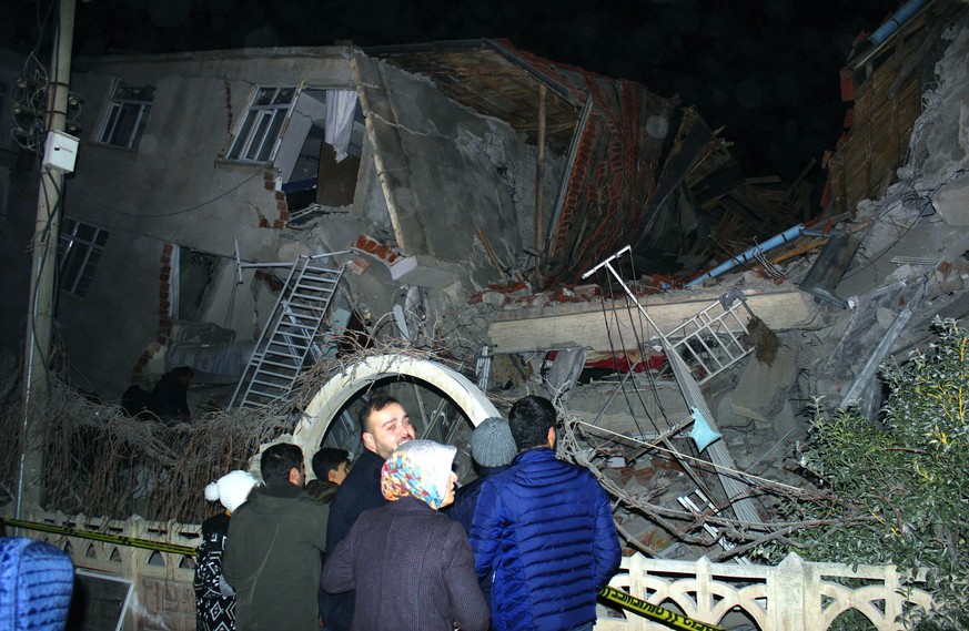 People look at a collapsed building after a 6.8 earthquake struck Elazig city centre in the eastern Turkey, Friday, Jan. 24, 2020. An earthquake with a preliminary magnitude of 6.8 rocked eastern Turk ...