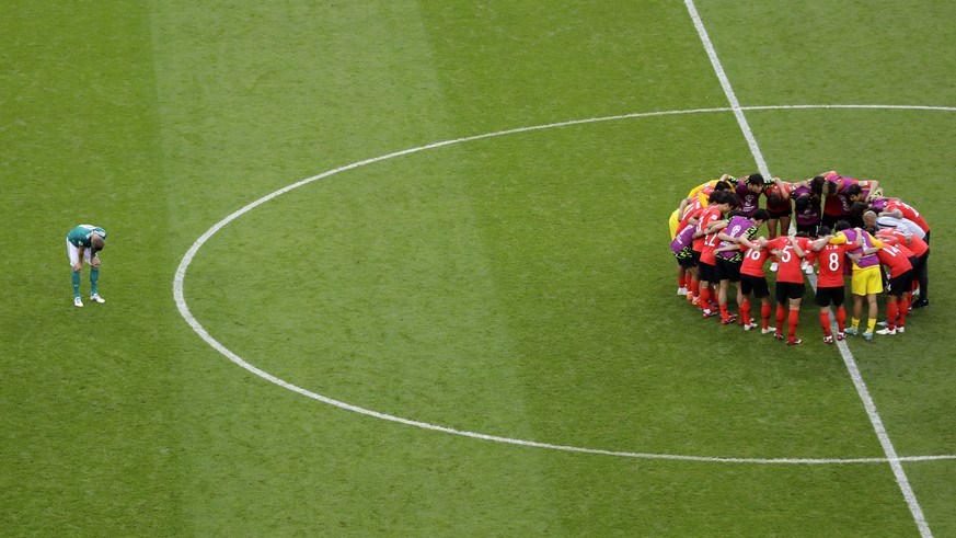 Germany&#039;s Toni Kroos bows on the field as South Korea players gather together at the end of the group F match between South Korea and Germany, at the 2018 soccer World Cup in the Kazan Arena in K ...