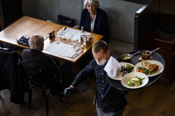 ARCHIVBILD ZUR GEPLANTEN OEFFNUNG DER INNENBEREICHE DER RESTAURANTS AB 31. MAI 2021 - A waiter of &quot;La Brasserie de Montbenon&quot; restaurant brings dishes food to customers during the spread of  ...