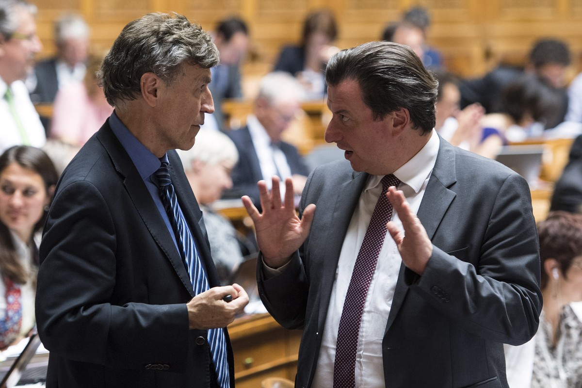Die Nationalraete Luzi Stamm, SVP-AG, links, und Corrado Pardini, SP-BE, diskutieren an der Herbstsession der Eidgenoessischen Raete in der Debatte zur Steuerung der Zuwanderung und Vollzugsverbesseru ...