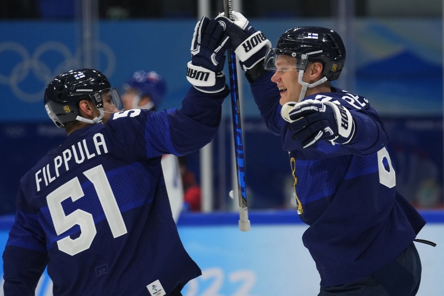 Finland&#039;s Harri Pesonen celebrates his goal on an empty net with teammate Valtteri Filppula, left, during a men&#039;s semifinal hockey game against Slovakia at the 2022 Winter Olympics, Friday,  ...