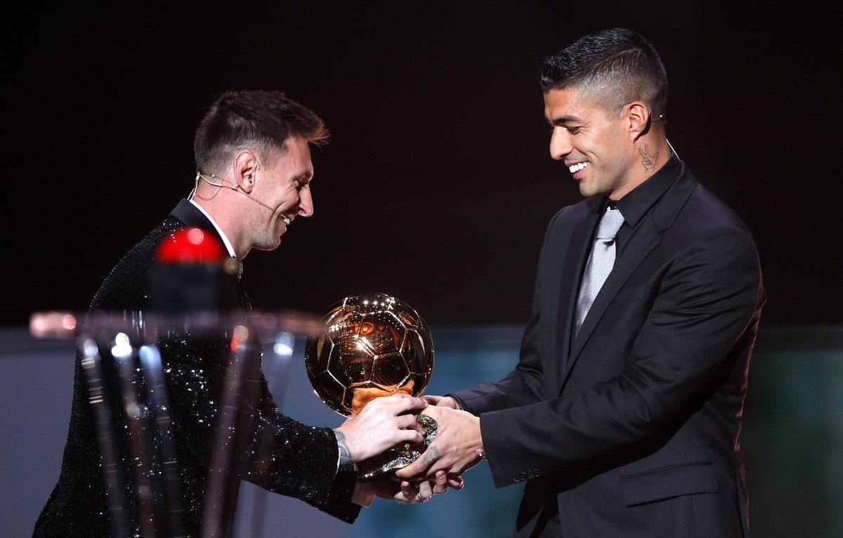 epa09611688 PSG player Lionel Messi (L) receives the Men's Ballon d'Or from his former Barcelona teammate Luis Suarez at the 2021 Ballon d'Or ceremony at Theatre du Chatelet in Paris, F ...