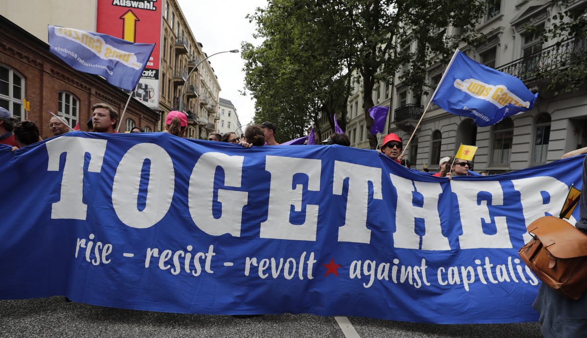 epa06076003 Protesters hold a banner at the 'Unlimited solidarity instead of G20' demonstration during the G-20 summit in Hamburg, Germany, 08 July 2017. The G20 Summit (or G-20 or Group of  ...